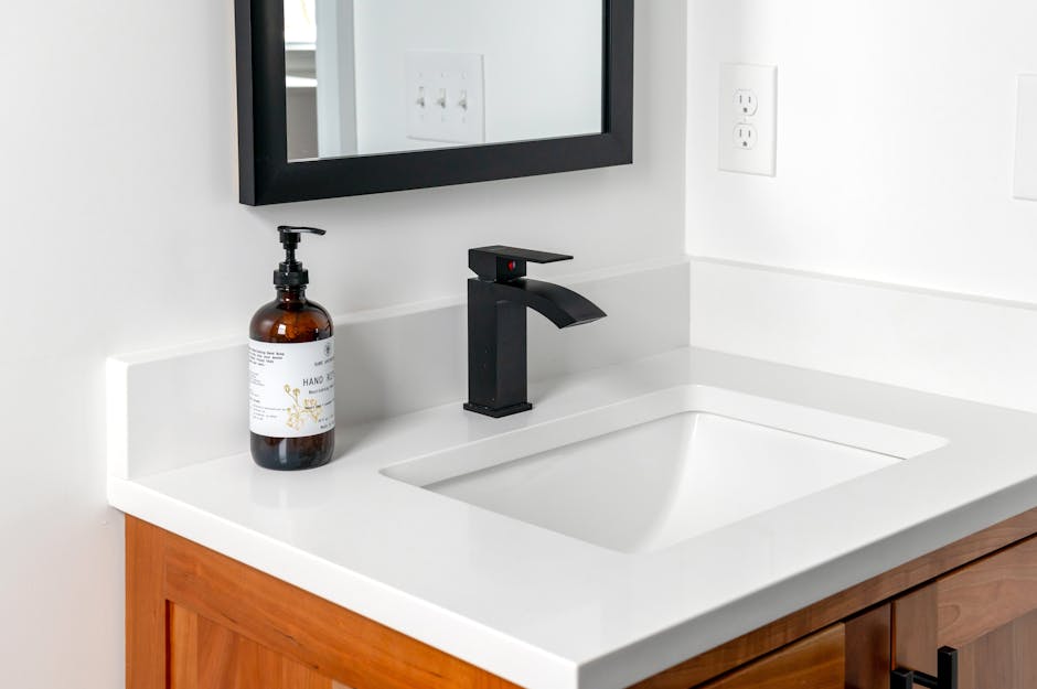 dornbracht - Stylish bathroom setup featuring a sleek black faucet, wall mirror, and elegant counter