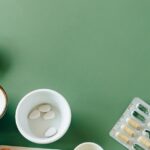 tisso - A flat lay of assorted pills and herbs on a green background emphasizing natural health reme